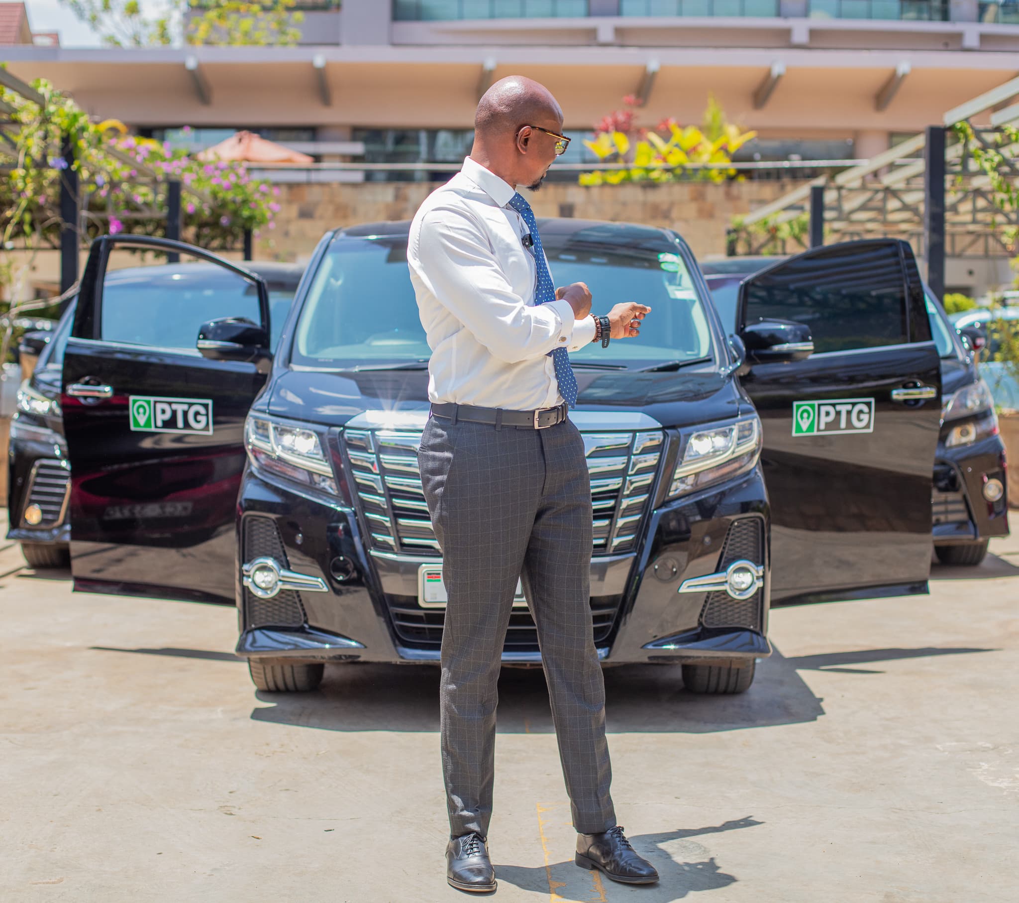 A PTG chauffeur beside the executive fleet